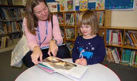 Mother and preschool daughter reading board book
