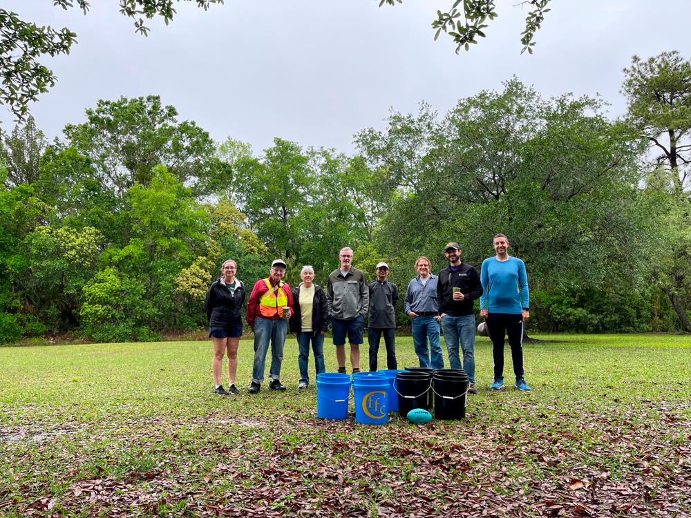 a group of Adopt-A-Park volunteers posing together outside in a park