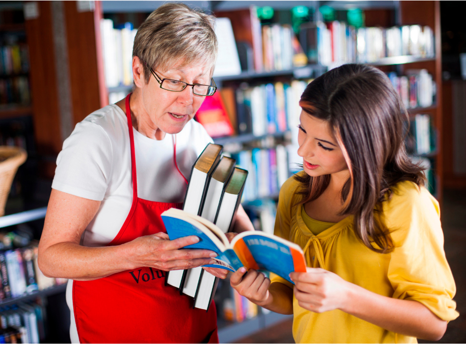 a librarian showing a young woman a book