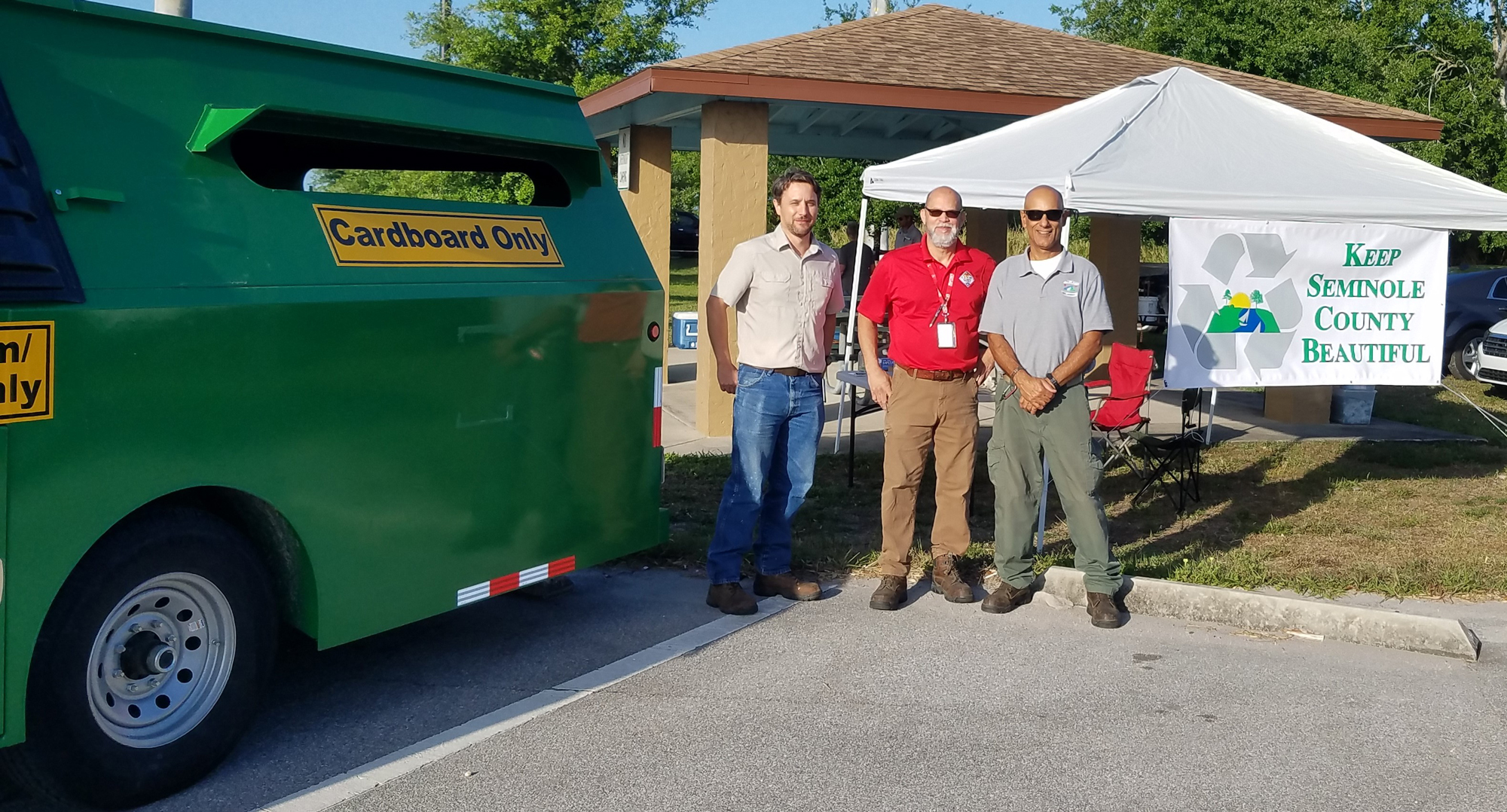 three seminole county solid waste management employees standing outside next to "BART" recycling trailer